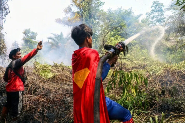 Un adolescente indonesiano vestito da supereroe aiuta a spegnere i fuochi nel Borneo
